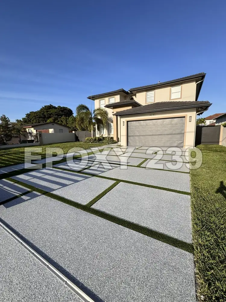 Modern house with a Stargazer flake epoxy driveway between strips of turf